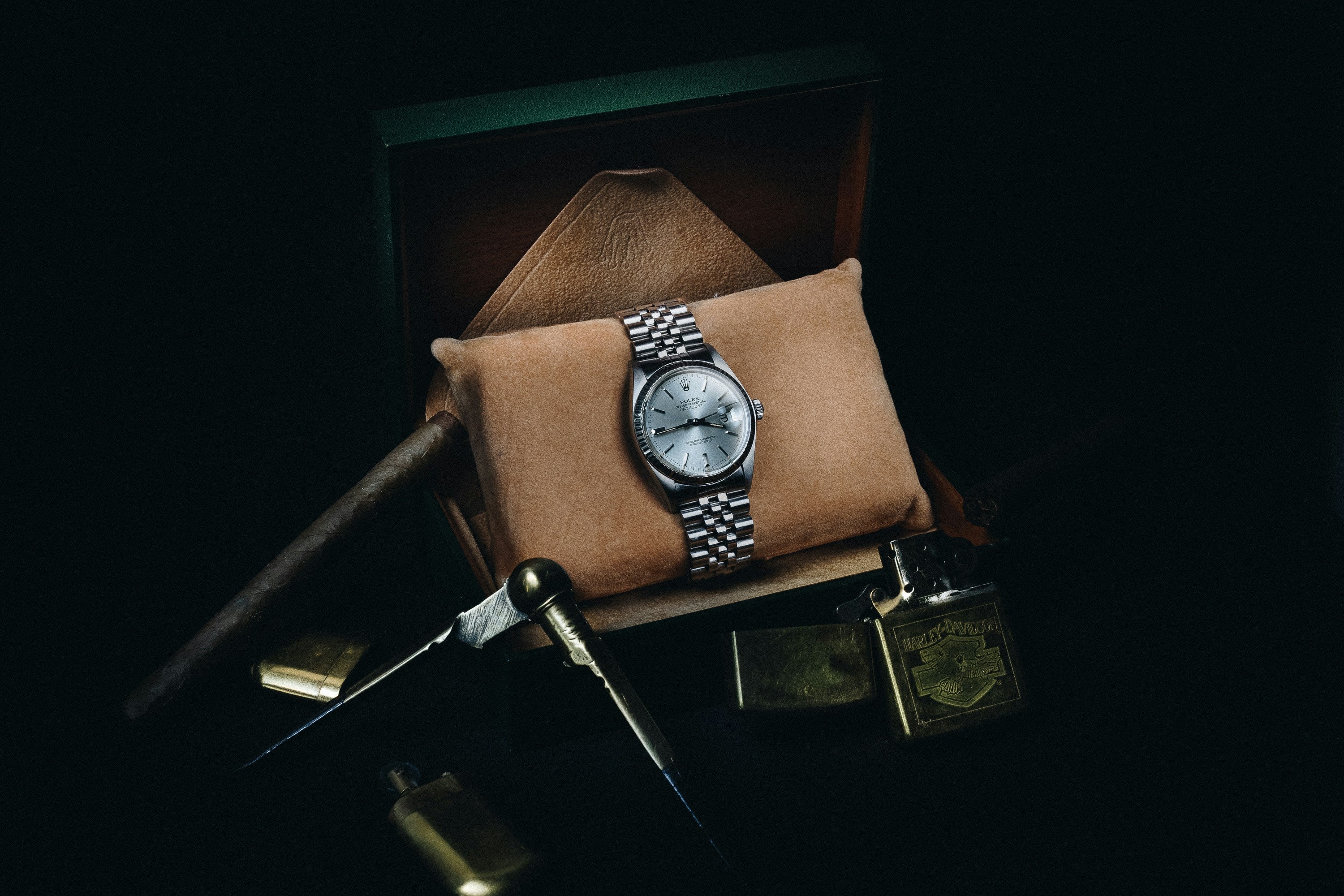 Close-up of Rolex Oyster Perpetual Date just with silver dial and jubilee bracelet resting on suede cushion.